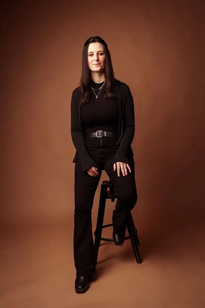 Mareike Pennig – Freelance Mediendesignerin im Portrait, stehend am Hocker, Über-mich-Bereich